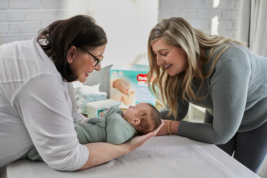 Midwife Cath holding wrapped newborn baby, with Mum